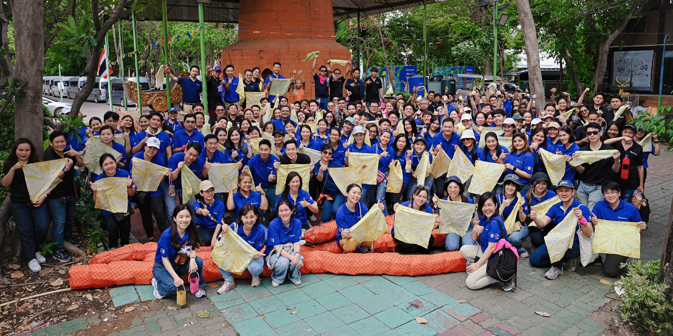 PepsiCo employees gather together holding up dyed cloths