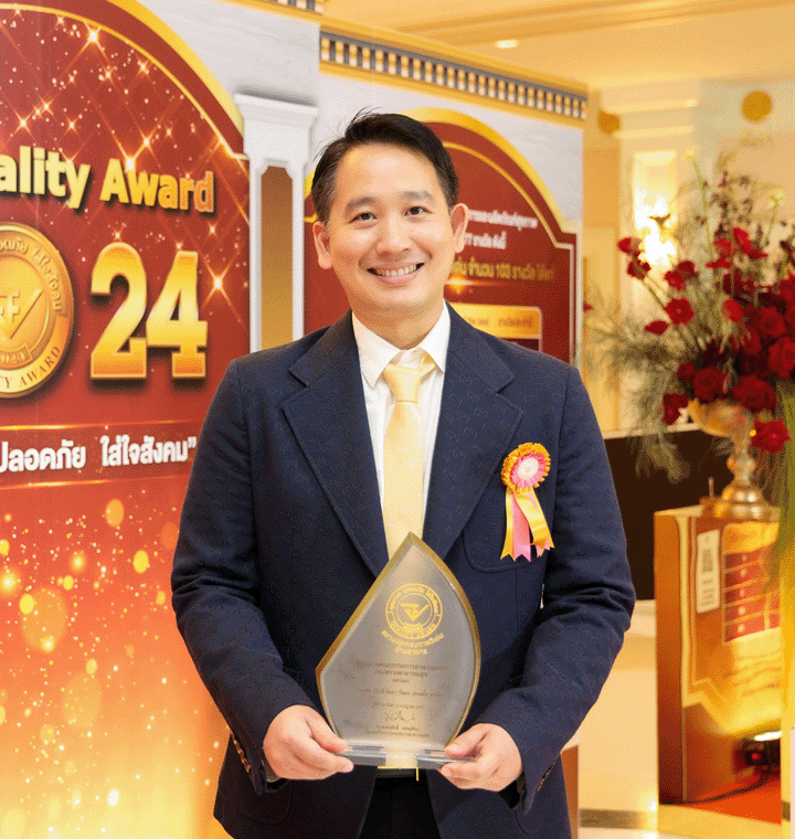 Employee holding an award and wearing a ribbon